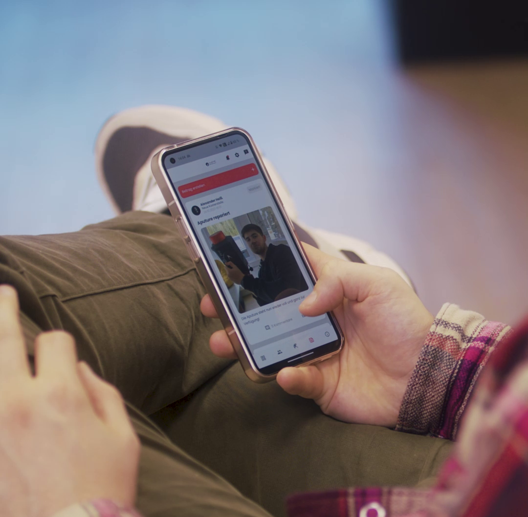 Person schaut auf dem Smartphone ein Video im Social-Media-Feed