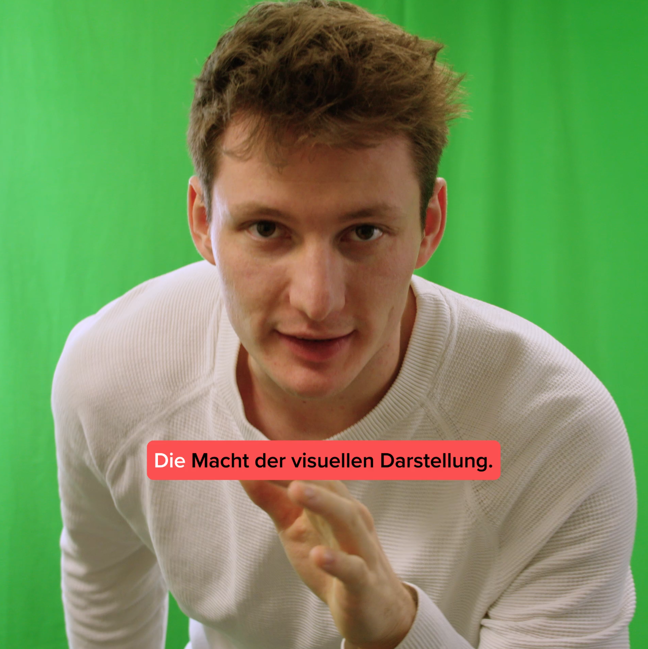 Sprecher vor grünem Greenscreen erklärt die Macht der visuellen Darstellung