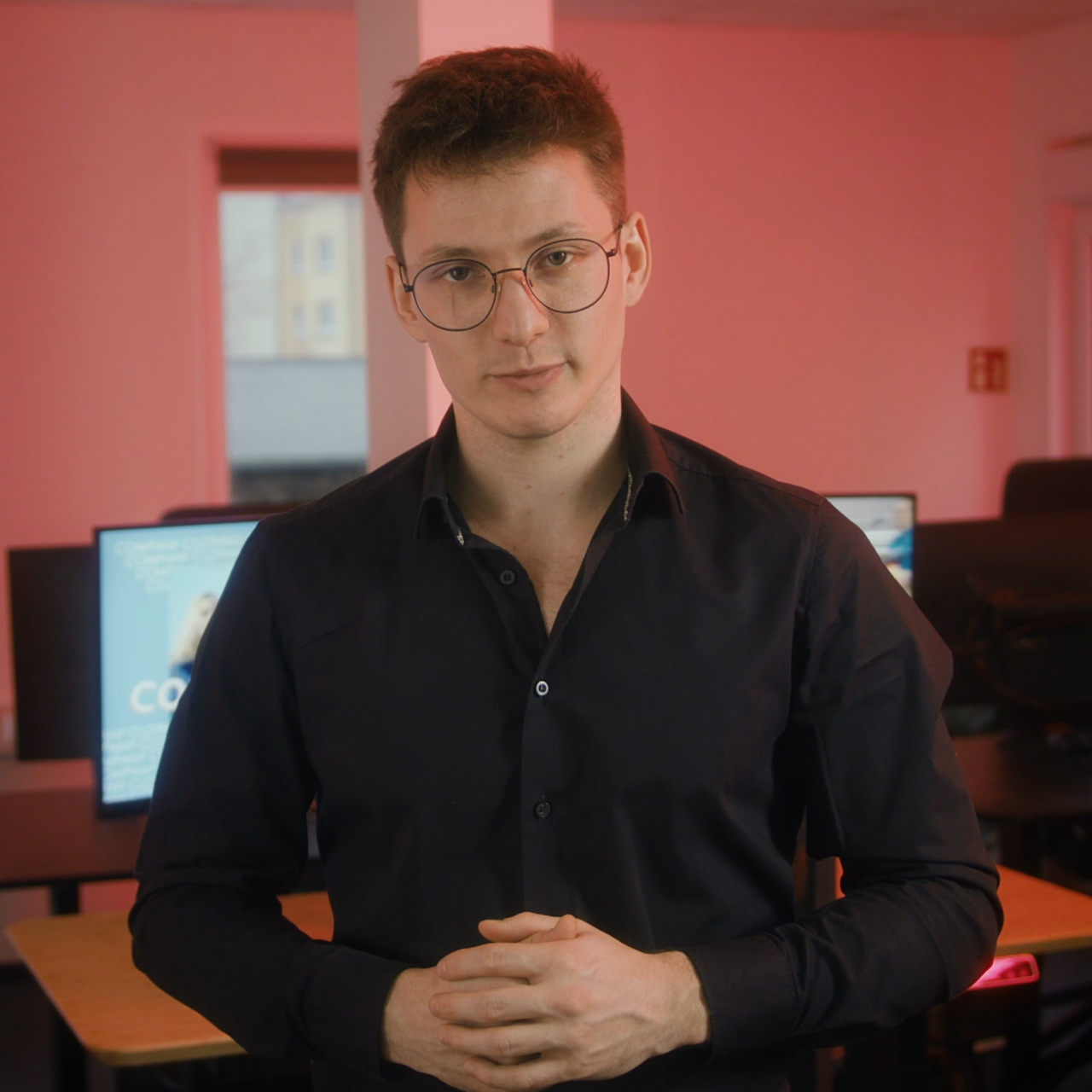 Mitarbeiter von Blackfire Medien im Interview vor rosa Wand im Büro
