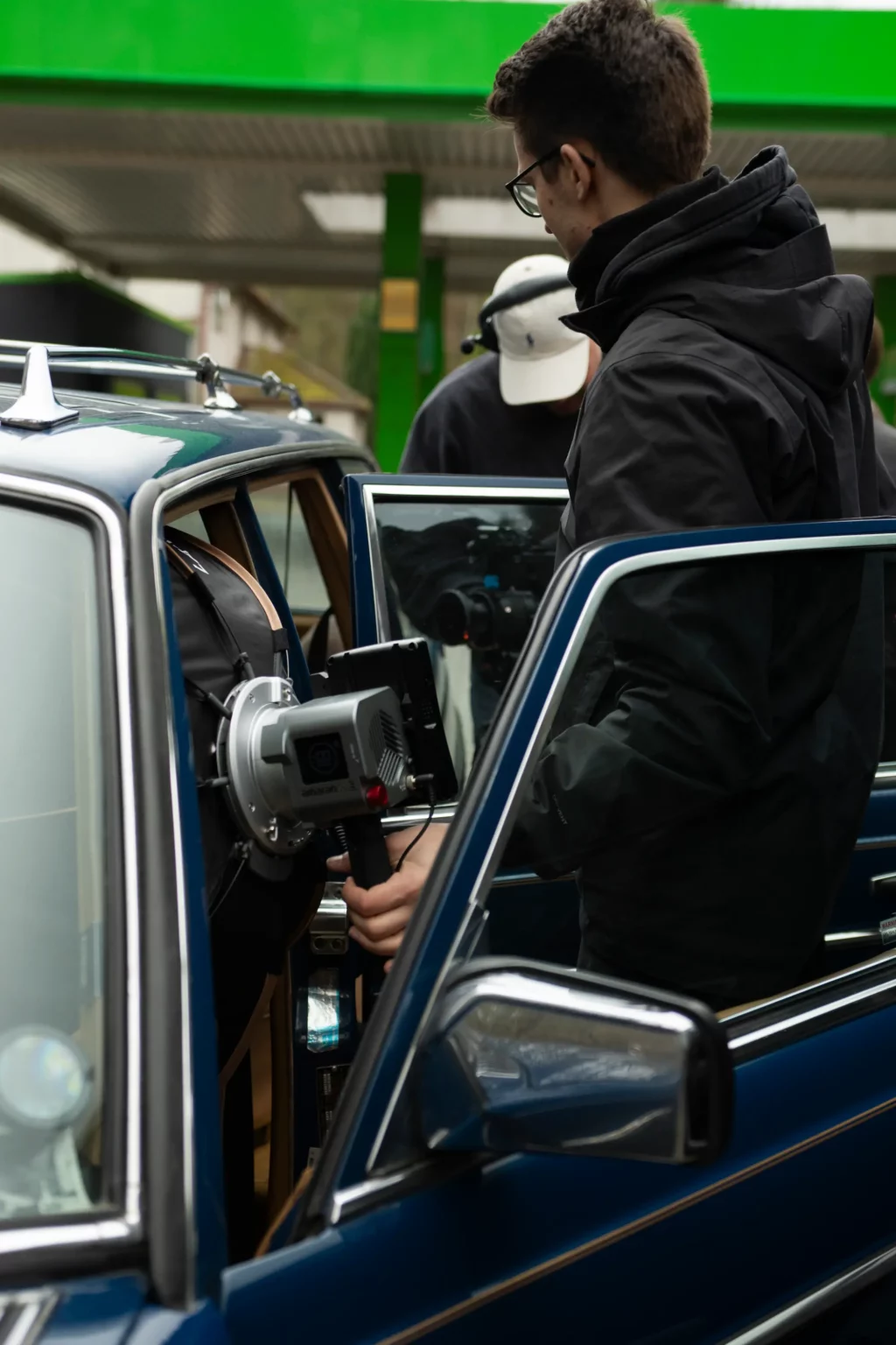 Kameramann von Blackfire® filmt an einem blauen Oldtimer bei einem Werbedreh
