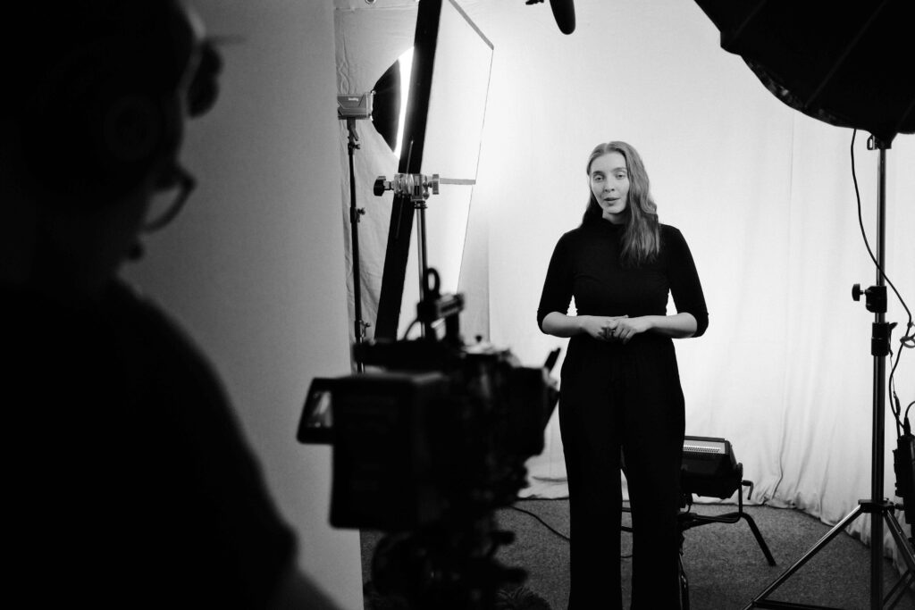 Filmteam von Blackfire® beim Studiodreh mit einer Sprecherin vor weißem Hintergrund