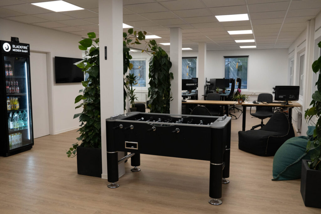 Büro von Blackfire® mit Kickertisch, Pflanzen und Arbeitsplätzen