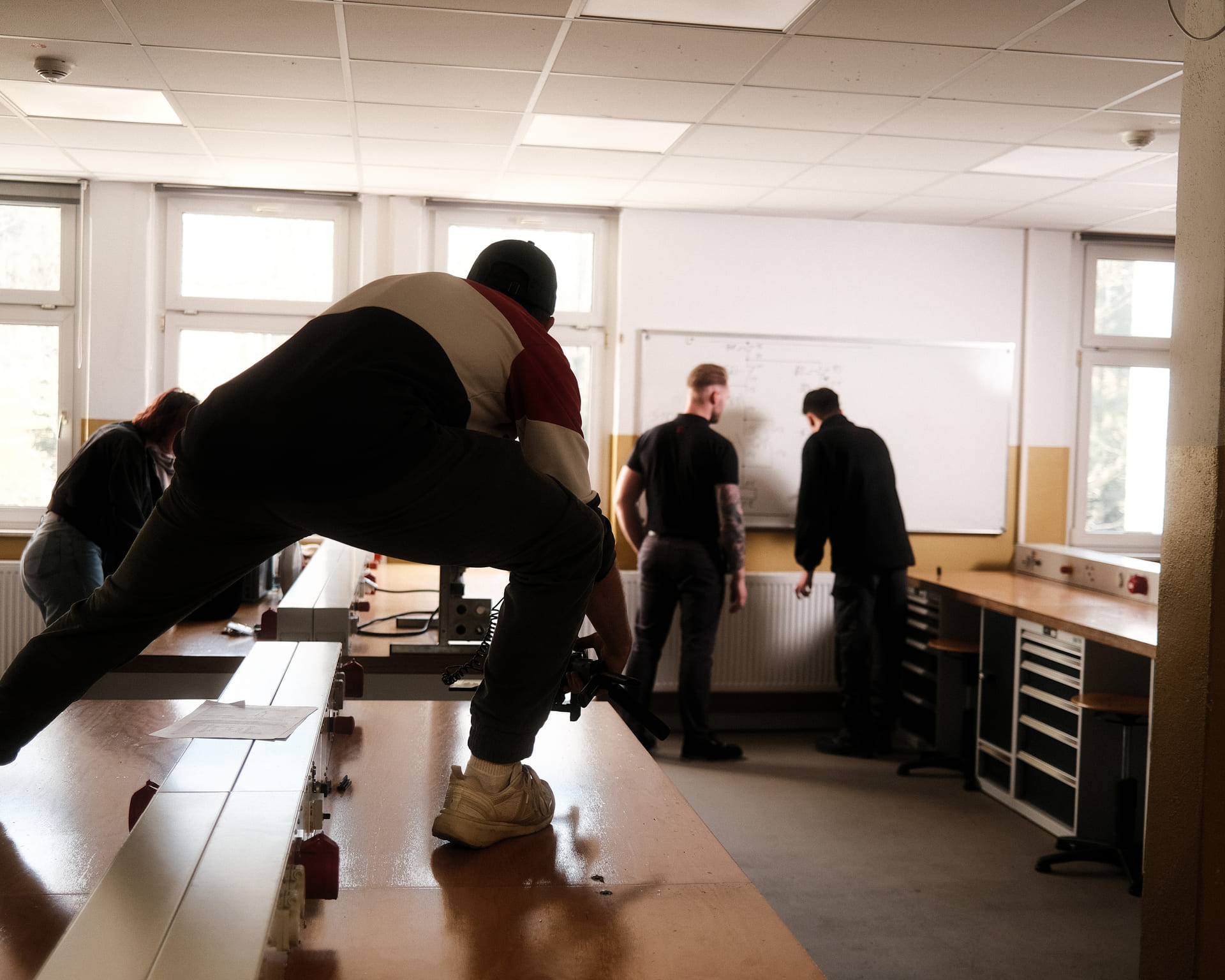 Kamerateam filmt zwei Mitarbeiter am Whiteboard in einer Werkstatt